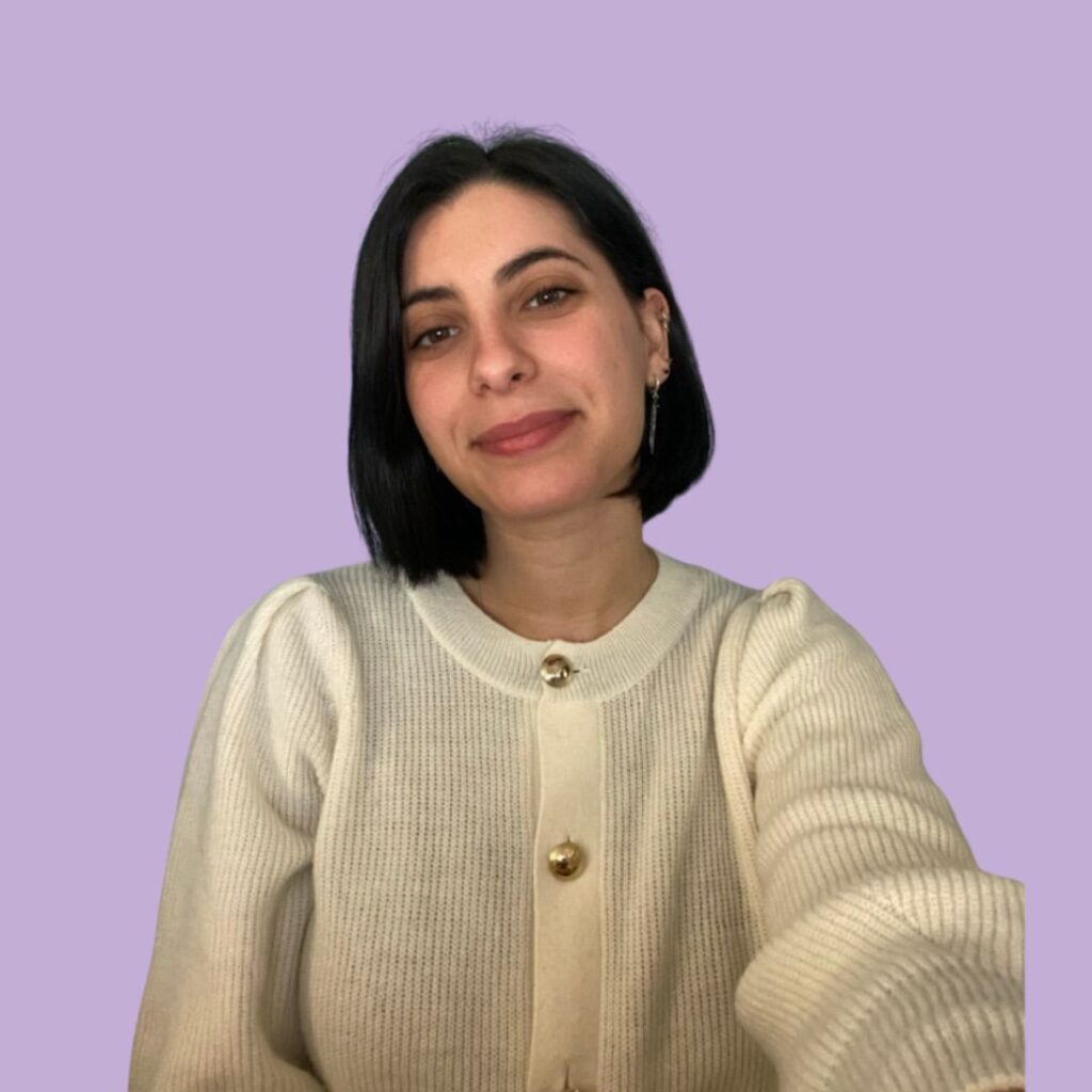 Ritratto professionale della Dott.ssa Bianca Raffaelli, psicologa e sessuologa a Firenze, con cardigan color crema su sfondo lilla.